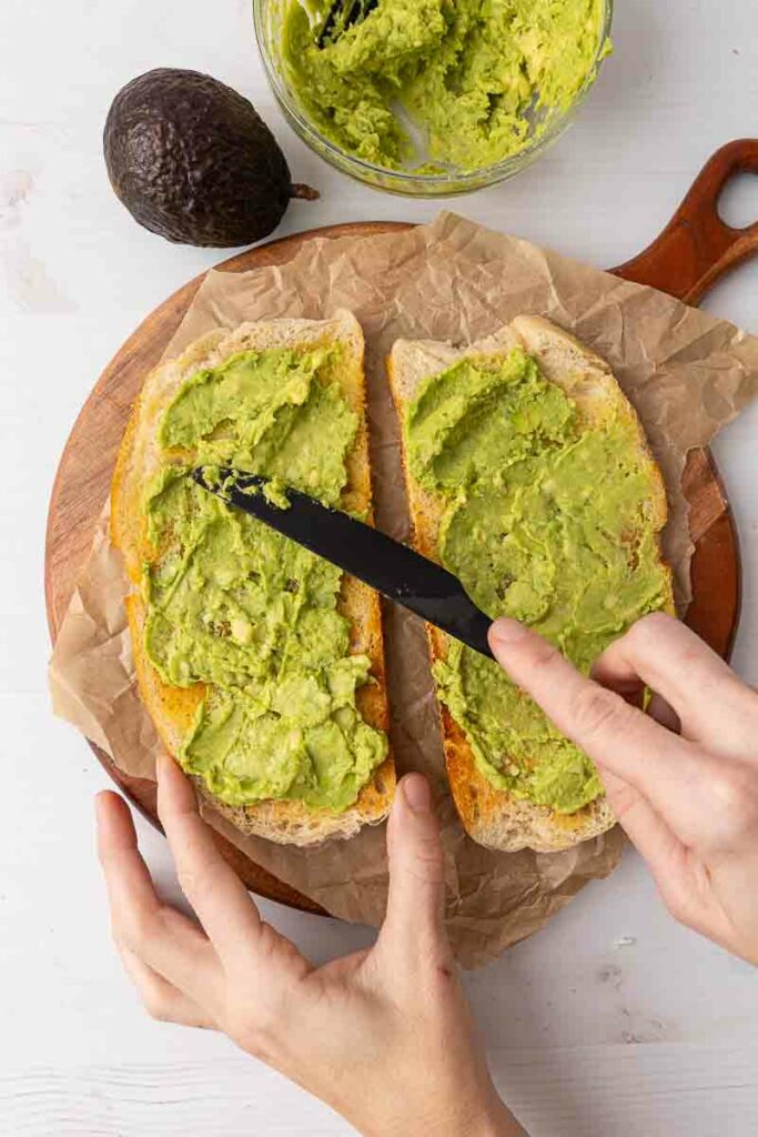 Το Mashed Avocado εξαπλώνεται σε δύο κομμάτια τοστ.